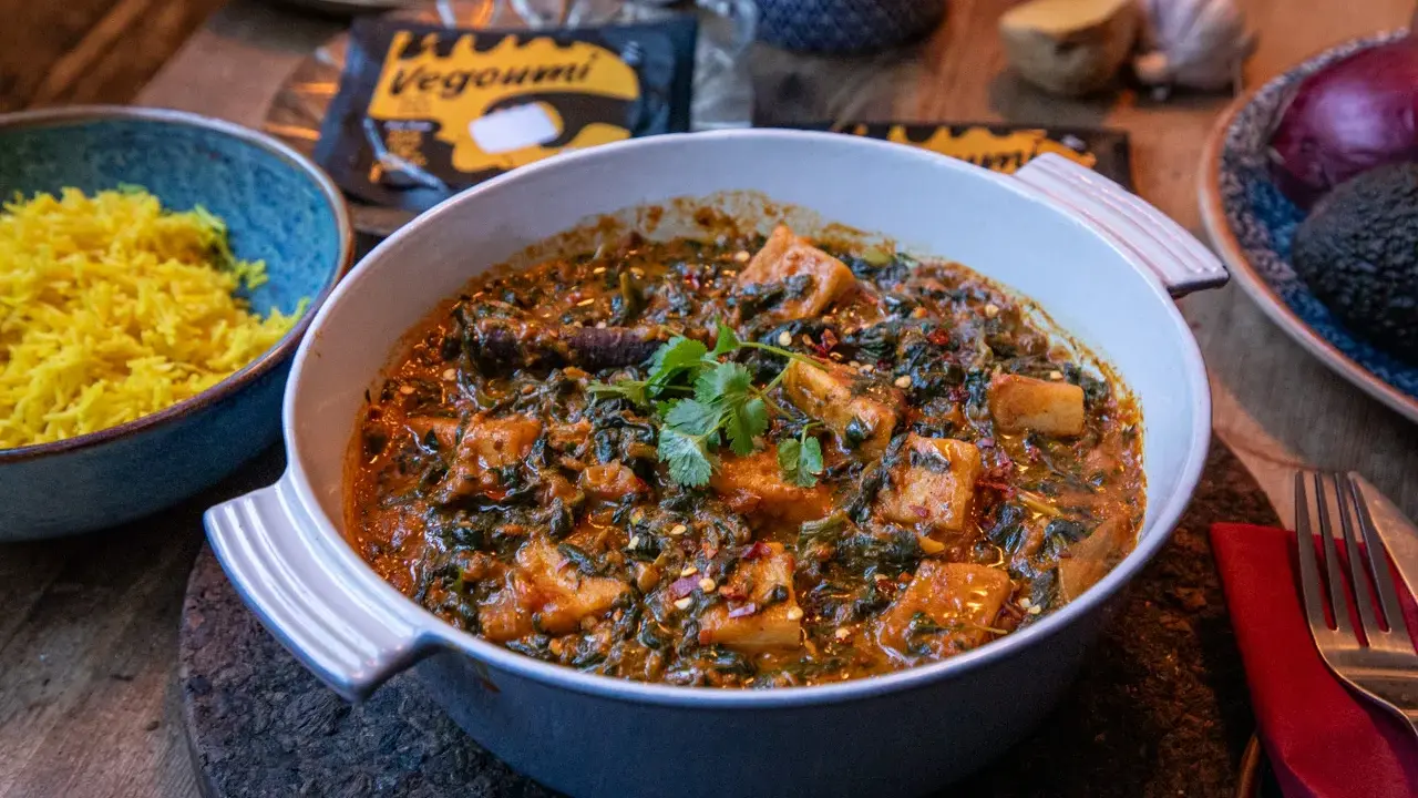 En krämig palak paneer med gyllene ris. Vegoumi-förpackning syns i bakgrunden.