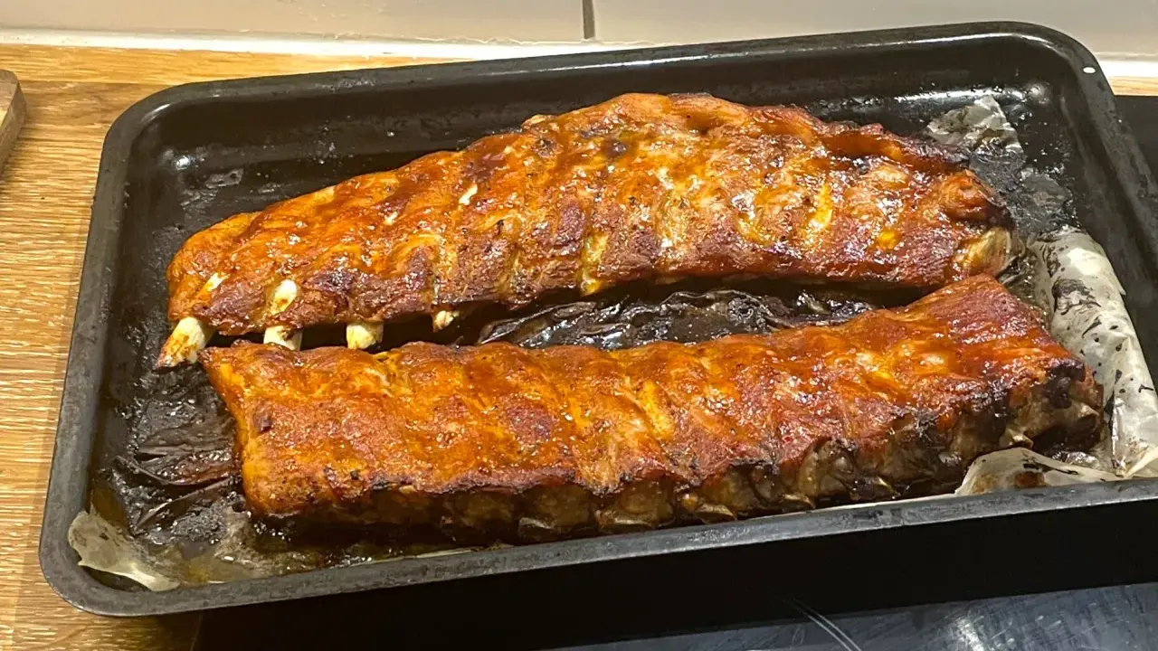 Två ugnsbakade kamben, glaserade och redo att serveras. Doften av BBQ sprider sig i köket.