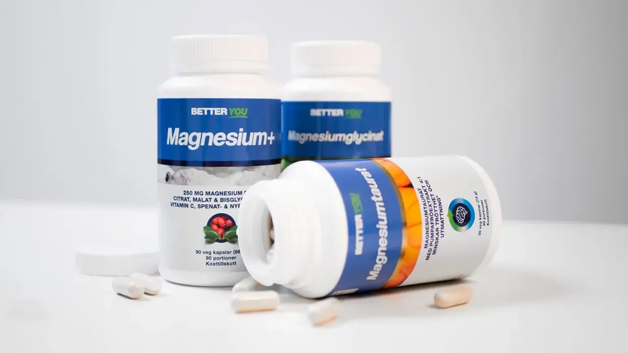 Tre burkar kosttillskott med magnesium. En burk ligger ner och visar texten "Magnesiumtaurat", som bidrar till att minska trötthet och utmattning, vilket är viktigt för magnesium i kroppen.