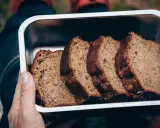 Skivor av saftig banankaka i en metallåda, perfekt för utflykten. Ett enkelt banankaka recept som alla kan lyckas med.