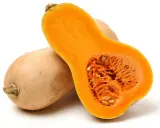 En hel och en halv butternutpumpa, med sitt orangea, fröfyllda inre. En riktigt nyttig och mångsidig grönsak.