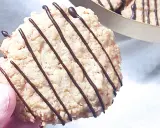 En hand håller en chokladglaserad havrekaka. Perfekt för ett enkelt havrekakor recept.