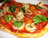 En läcker glutenfri pizza med tomatsås, grönsaker som lök, paprika, champinjoner, kronärtskocka och färsk spenat, toppad med balsamvinäger.