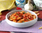 En skål med pasta arrabiata, toppad med färsk persilja. En klassisk italiensk rätt som värmer själen.