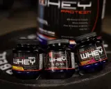Tre små burkar med proteinpulver, Prostar 100% Whey Protein, i smakerna Mango, Chocolate Birthday Cake och Peanut Butter & Jelly. Dessa naturliga kosttillskott är perfekta för träning.