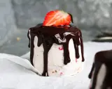 En himmelsk jordgubbstårta med chokladglasyr och en färsk jordgubbe på toppen. En dröm för alla sötsugna!