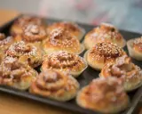 En plåt med nybakade glutenfria kanelbullar, toppade med pärlsocker. Doften av kanel sprider sig i köket.