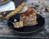 En skiva pannkakstårta med lager av grädde och kakao, perfekt för ett tiramisu recept.