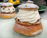 Två fluffiga semlor med rikligt med grädde och mandelmassa till semlor. Pudrade med florsocker och garnerade med mandelbitar.