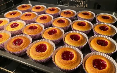 Nybakade hallongrottor i sina lila formar, redo att avnjutas. Ett perfekt hallongrottor recept för fikat.