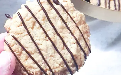 En hand håller en chokladglaserad havrekaka. Perfekt för ett enkelt havrekakor recept.