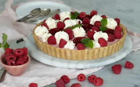En vacker cheesecake hallon med vispgrädde och färska hallon. Perfekt för sommaren!
