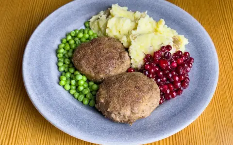 Två Wallenbergare med potatismos, gröna ärtor och rårörda lingon. Ett klassiskt svenskt recept som passar alla.