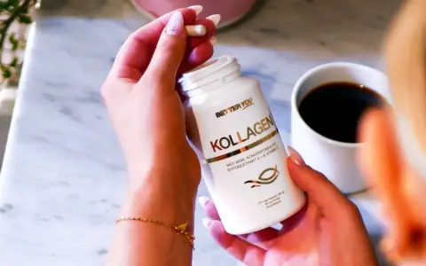 En hand håller en kapsel från en Better You Kollagen-burk. En kopp kaffe står bredvid. För en bättre du, natt biverkningar är minimala.
