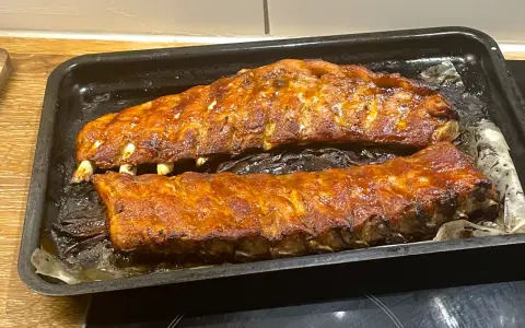Två ugnsbakade kamben, glaserade och redo att serveras. Doften av BBQ sprider sig i köket.