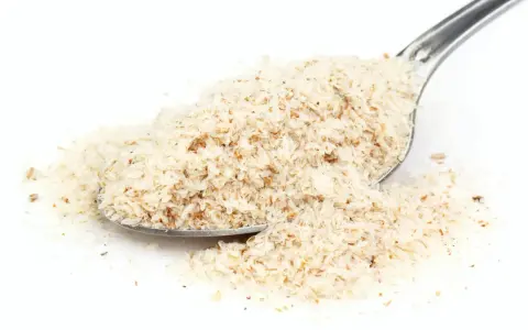 En sked med psylliumfröskal, som kan ge husk biverkningar om det inte tas med tillräckligt med vätska.