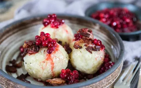 Tre runda pitepaltar toppade med lingon och knaperstekt fläsk. Ett klassiskt pitepalt recept som ser utsökt ut!