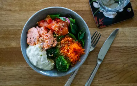 En härlig poke bowl med lax, broccoli, tomat och rivna morötter. Ett perfekt poke bowl recept för en hälsosam lunch.