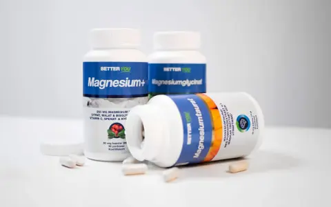 Tre burkar kosttillskott med magnesium. En burk ligger ner och visar texten "Magnesiumtaurat", som bidrar till att minska trötthet och utmattning, vilket är viktigt för magnesium i kroppen.