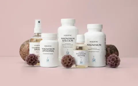 Holistic magnesiumprodukter: spray, liposomalkapslar, magnesium-kalciumkapslar, droppar och magnesiumcitratkapslar, dekorerade med stenar och torkade blommor.