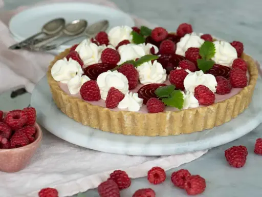 En vacker cheesecake hallon med vispgrädde och färska hallon. Perfekt för sommaren!