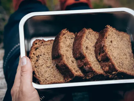Skivor av saftig banankaka i en metallåda, perfekt för utflykten. Ett enkelt banankaka recept som alla kan lyckas med.