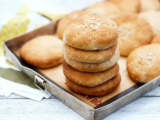 En stapel nybakade tekakor med havregryn på toppen, redo att avnjutas. Ett enkelt tekakor recept för hembakat bröd.