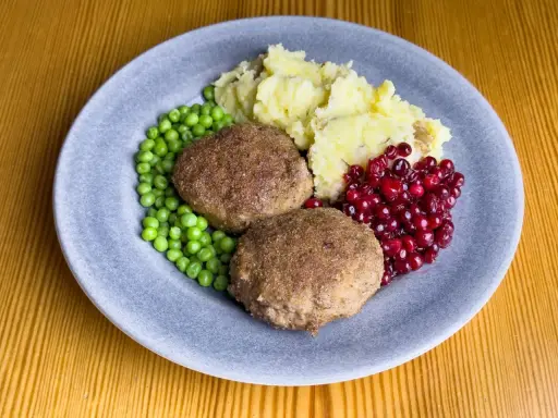 Två Wallenbergare med potatismos, gröna ärtor och rårörda lingon. Ett klassiskt svenskt recept som passar alla.