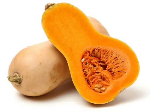 En hel och en halv butternutpumpa, med sitt orangea, fröfyllda inre. En riktigt nyttig och mångsidig grönsak.
