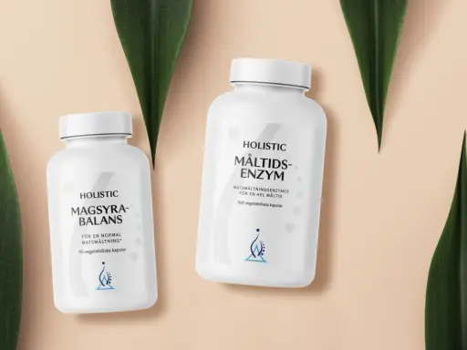 Två burkar med Holistic magsyra-balans och måltids-enzym, omgivna av gröna blad.