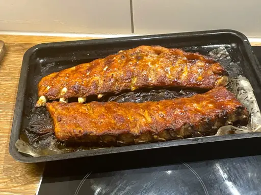 Två ugnsbakade kamben, glaserade och redo att serveras. Doften av BBQ sprider sig i köket.