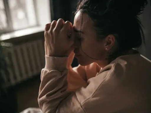 En kvinna med händerna mot pannan, kanske upplever hon biverkningar av Propavan.