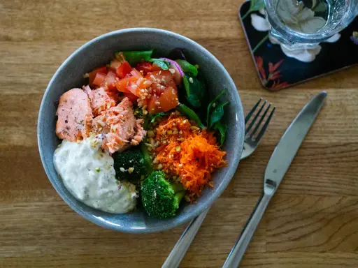En härlig poke bowl med lax, broccoli, tomat och rivna morötter. Ett perfekt poke bowl recept för en hälsosam lunch.