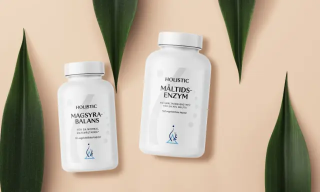 Två burkar med Holistic magsyra-balans och måltids-enzym, omgivna av gröna blad.
