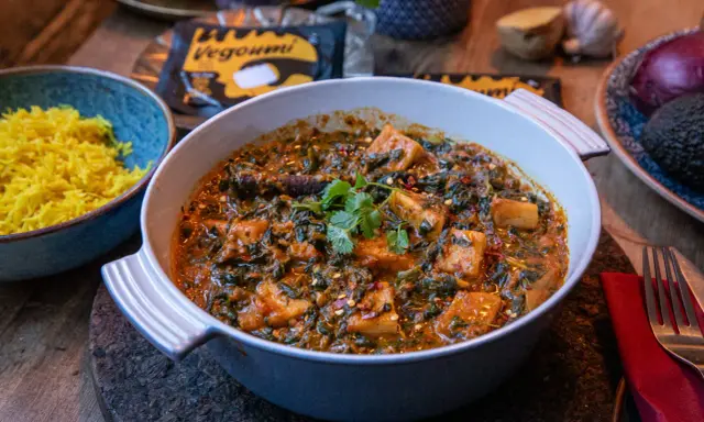 En krämig palak paneer med gyllene ris. Vegoumi-förpackning syns i bakgrunden.