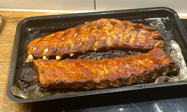 Två ugnsbakade kamben, glaserade och redo att serveras. Doften av BBQ sprider sig i köket.