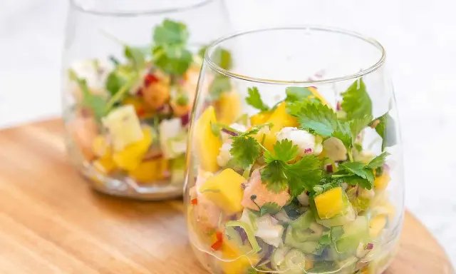 Två glas med färgglad ceviche, perfekt för ett somrigt ceviche recept med mango, koriander och chili.
