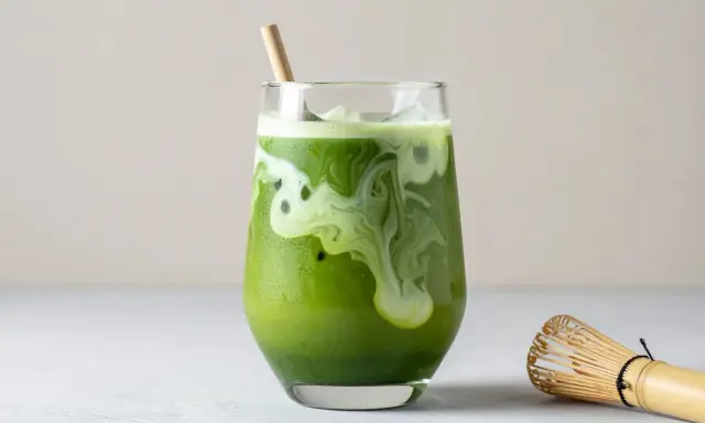 En krämig islatte med virvlande mönster, en bambuvisp bredvid. Matcha nyttigt och gott!