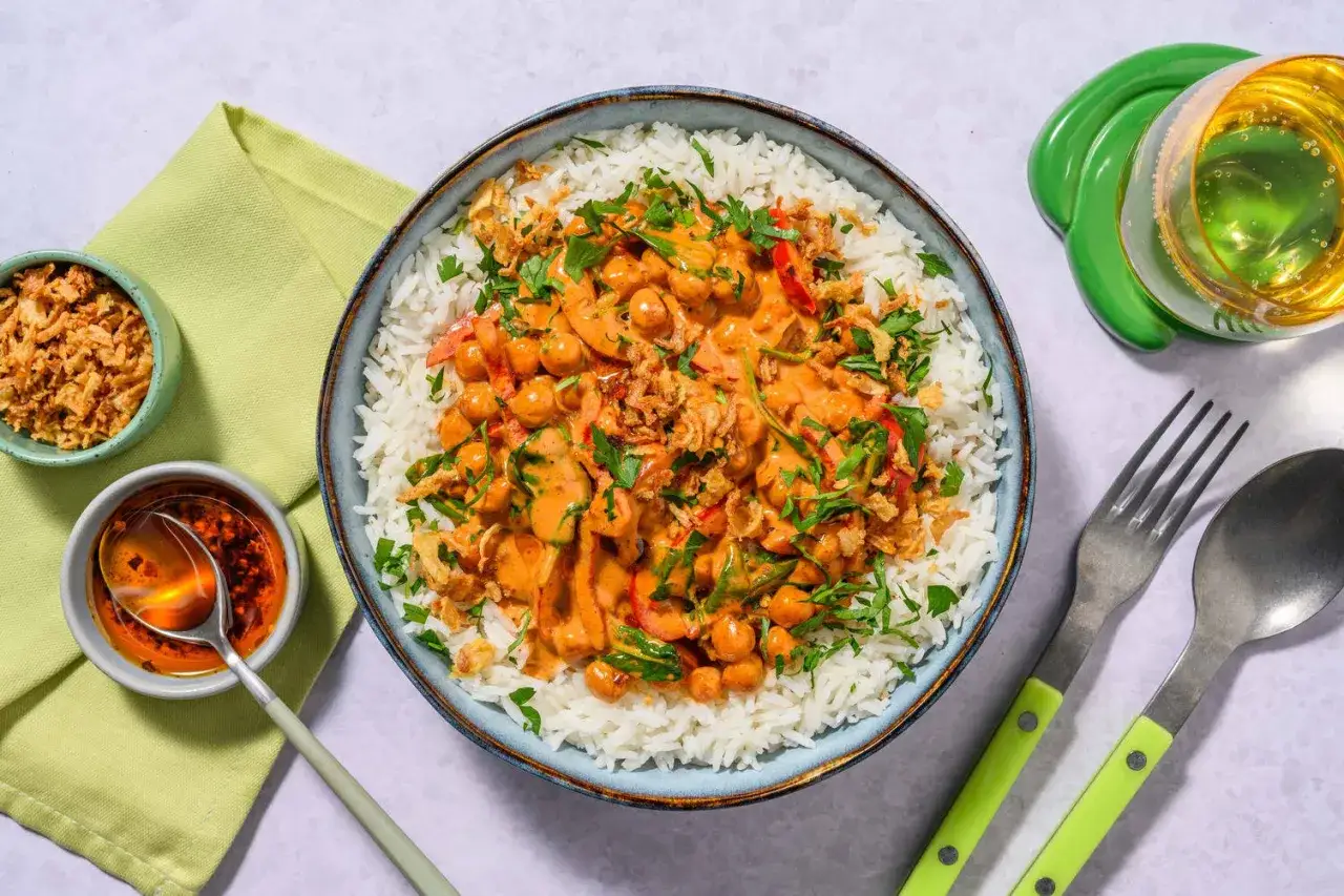 En sk&aring;l med fluffigt ris toppad med en kr&auml;mig kik&auml;rtscurry med paprika och toppad med krispig l&ouml;k och persilja. En h&auml;rlig thai mat-upplevelse.
