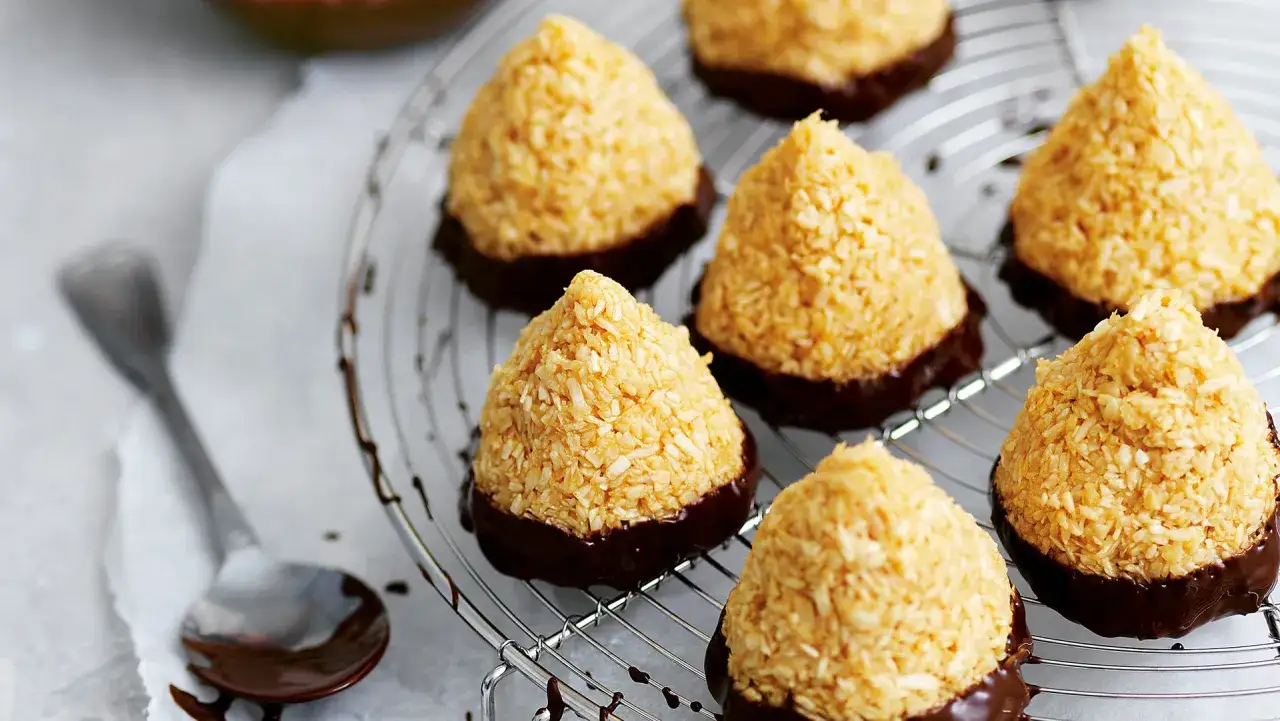 Sm&aring;, konformade kokostoppar med chokladbotten p&aring; ett galler. Perfekt f&ouml;r ett enkelt kokostoppar recept.
