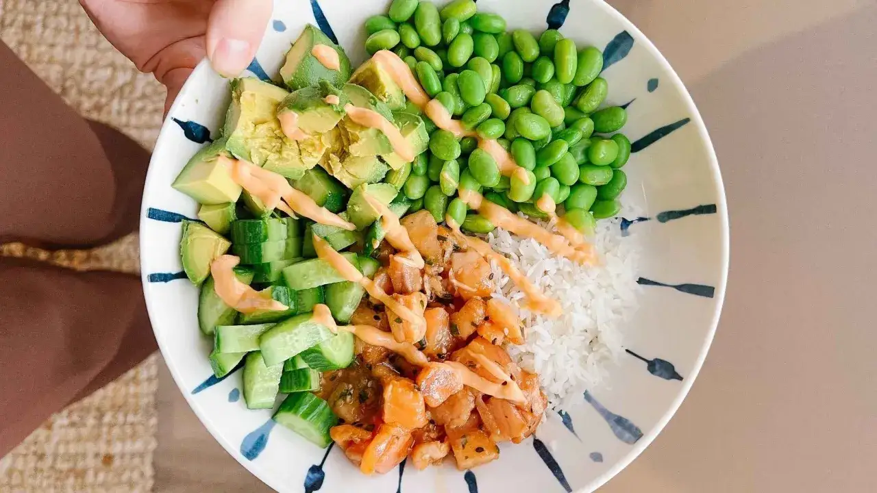 En f&auml;rgglad poke bowl med lax, ris, edamameb&ouml;nor, gurka och avokado. Perfekt som ett snabbt och h&auml;lsosamt poke bowl recept.