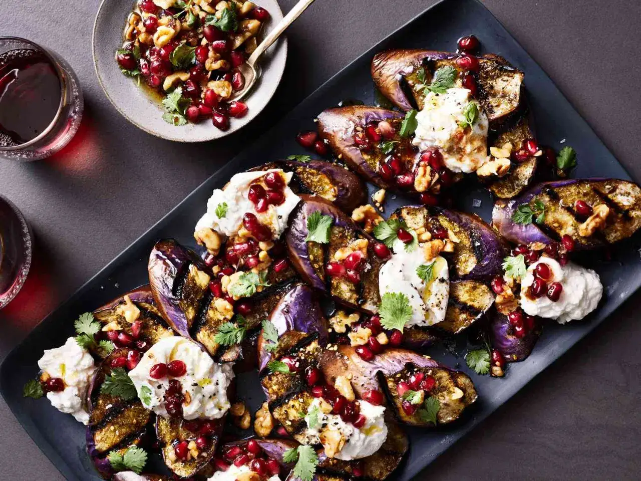 Grillad aubergine med kr&auml;mig ost, granat&auml;pple och n&ouml;tter. Ett l&auml;ckert aubergine recept som passar perfekt som f&ouml;rr&auml;tt eller tillbeh&ouml;r.