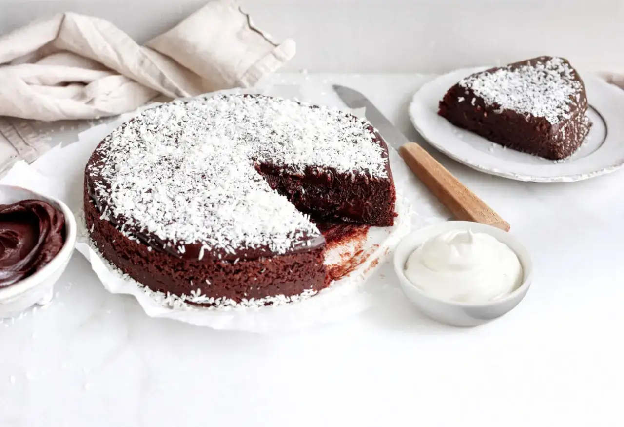 Kladdkaka med kokosflingor, perfekt för ett enkelt kladdkaka recept. Serveras med vispad grädde och chokladkräm.